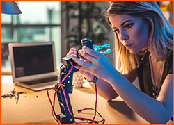 Woman working on a project with a laptop in background