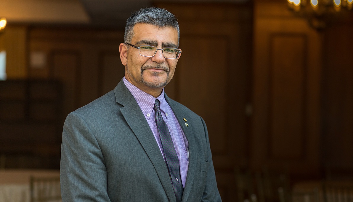 Babak Dastgheib Beheshti pictured at waist height, wearing a suit and tie and smiling at the camera.