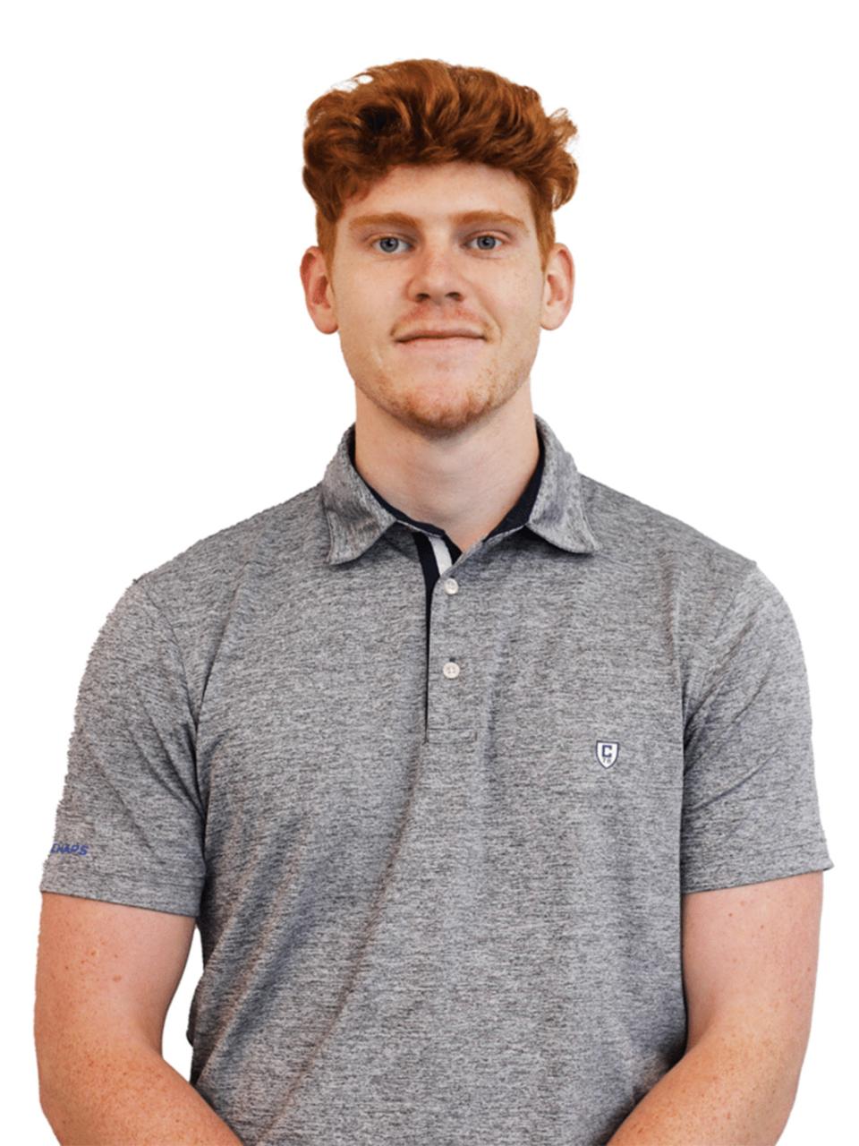 Image of a young man with red hair smiling at the camera